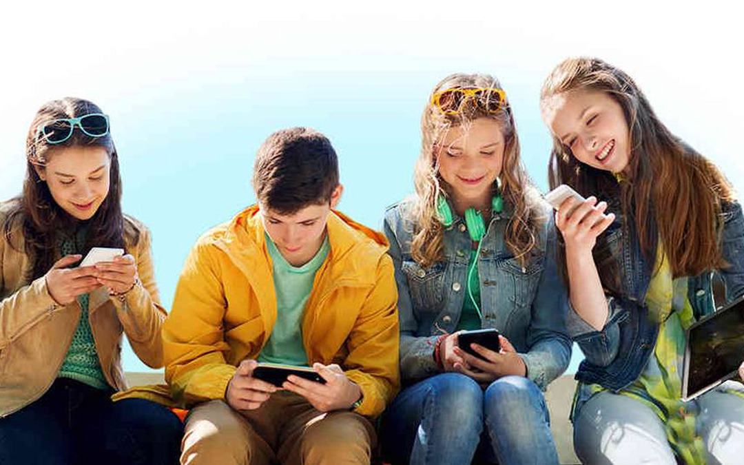 Niños viendo redes sociales en los móviles