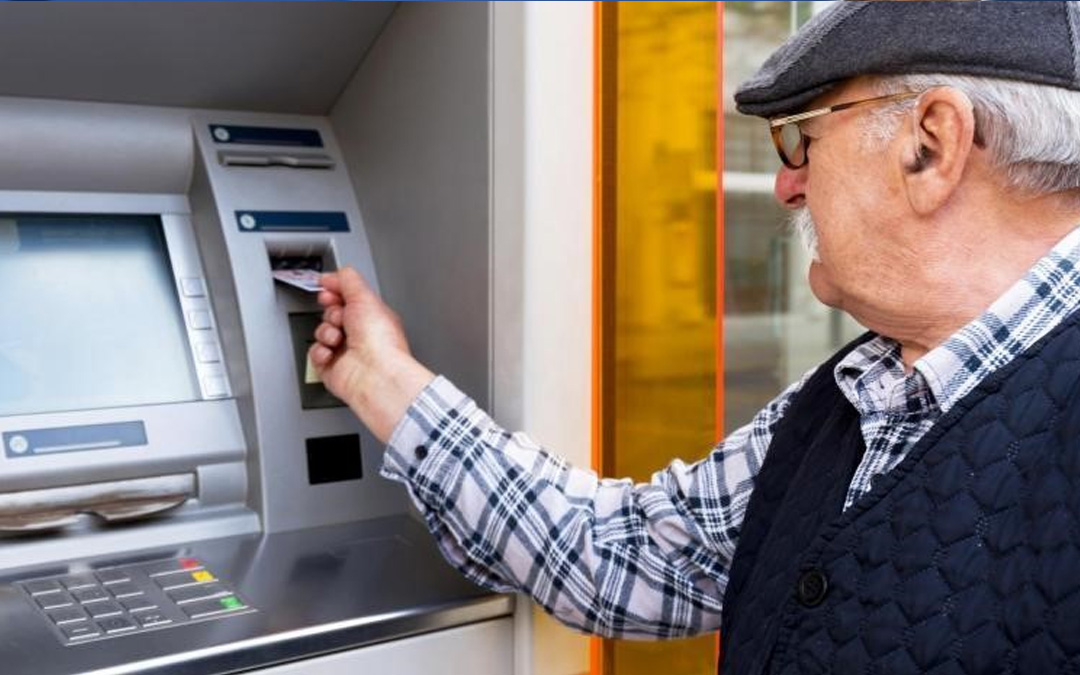 Persona mayor sacando dinero de un cajero
